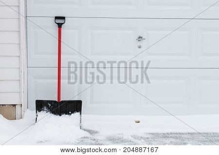 a snow shovel leaning on garage door.