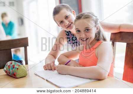 A cute teen girl doing homework at home