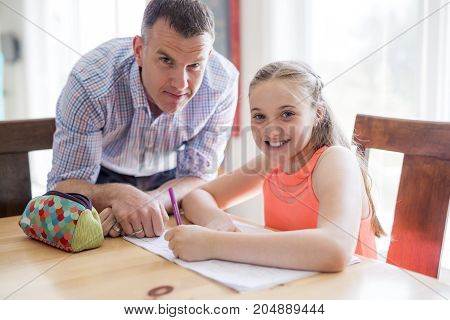 A Male Home Tutor Helping Teenage Girl With Studies