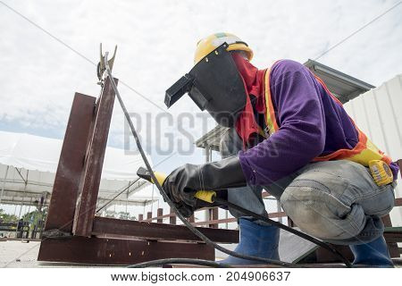Industrial welder welding fabricated construction in factory Welding process by Shielded Metal Arc Welding (SMAW) or Stick Welding.
