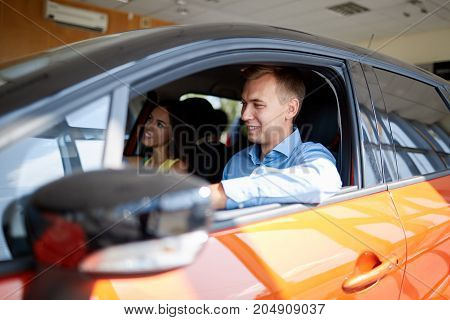The beautiful couple chose a new car for themselves. The concept of buying a new car.