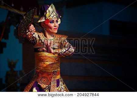 Denpasar Bali island Indonesia - June 28 2015: Face portrait of beautiful Balinese woman in ethnic dancer costume dancing traditional temple dance.