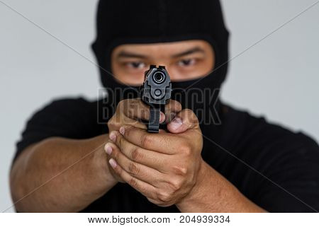 Armed man in a hoodie is pointing a handgun at the target.