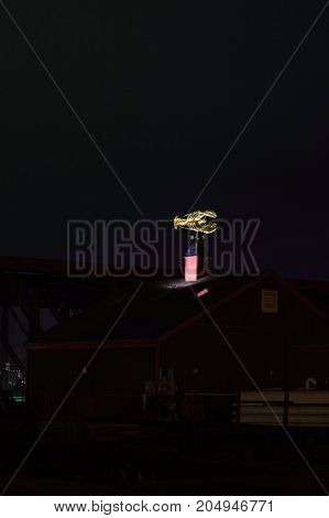 Boston Massachusetts USA - January 19 2017: Illuminated golden lobster atop James Hook & Co. restaurant in pre-dawn darkness