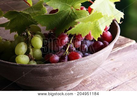 Grapes on wooden table and grape leaves . Healthy fresh fruit wine grapes.