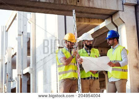 Portrait of construction engineers working on building site together