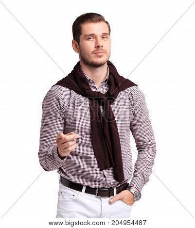 Cheerful attractive young man smiling and pointing at camera over white background