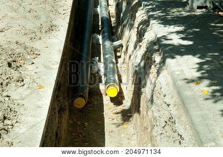 Excavation site to replacing underground hot water pipeline down the street in the city district before winter heating season come