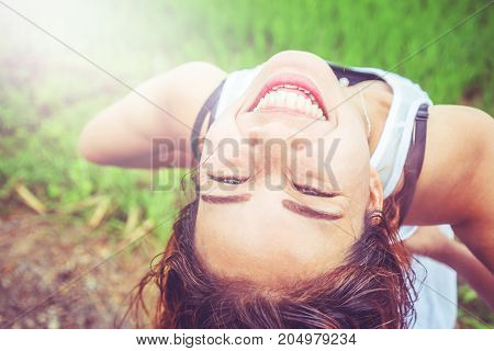 Asian women travel relax in the holiday. Stand in a meadow in the rain. On the meadow During the rainy season.Thailand