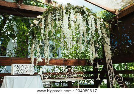 Wedding arch decorated with white hanging flowers