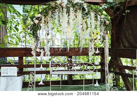 Wedding arch decorated with white hanging flowers