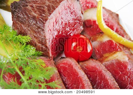 半生的牛肉肉与蔬菜在白板上