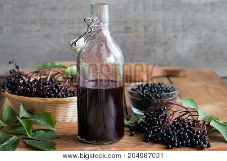 A Bottle Of Elderberry Syrup On A Wooden Background