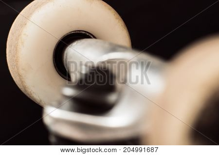 Close up skateboard wheels on black background, focus on background. Repairing and adjustment of professional extreme sport devices and skateboarding elements. Chassis, kingpin, hanger