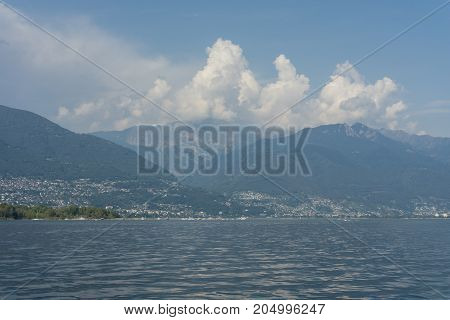 lago maggiore lake scenery with mountain water and cloudy sky in summer from boat
