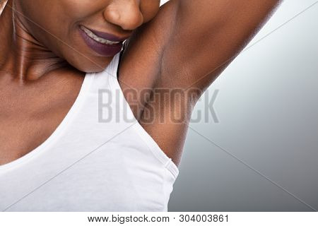 Close-up Of A Woman Showing Clean Underarms On Grey Background