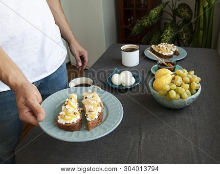 A Tasty Breakfast Fowr Two: Rye Bread Sandwiches, Fresh Fruits, Eggs, Honey And Coffee.