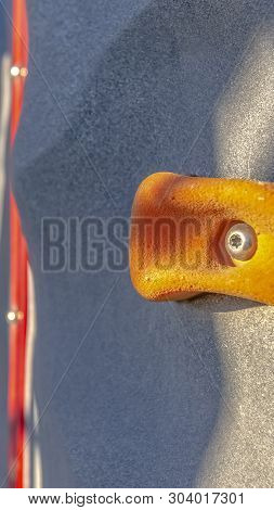 Vertical Bright Orange Foothold Or Handhold Of A Climbing Wall At A Playground