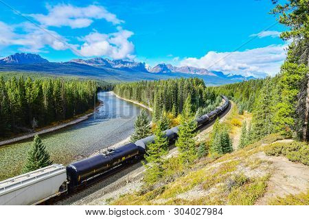Long Freight Train Moving Along Bow River In Canadian Rockies ,banff National Park, Canadian Rockies