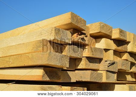 Stacked Lumber On Blue Sky.folded Wood.closeup Wooden Boards.the Surface Of The End Of The Board.lot