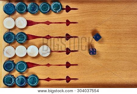 Backgammon Game. Game Dice Made Of Stone Lie On The Backgammon Board Against The Background Of Check