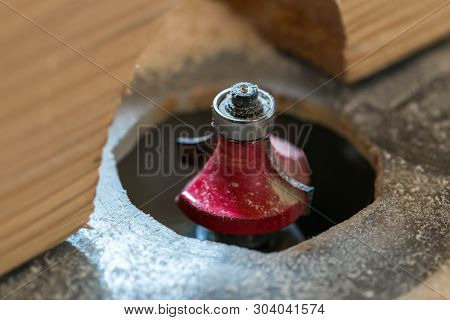 Red Router Bit Close Up Macro Shot In A Small Woodwork Shop.
