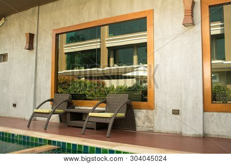 Warm Light Neutral And Pool With Two Wicker Chairs