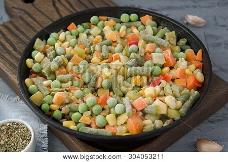 Frozen Chopped Vegetables In A Boiling Pan With Spices. Vegan Food.