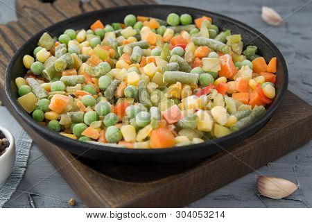 Frozen Chopped Vegetables In A Boiling Pan With Spices. Vegan Food.