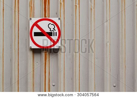 Corrugated Iron Gray Rusty Wall With A Sign Hanging On It No Smoking