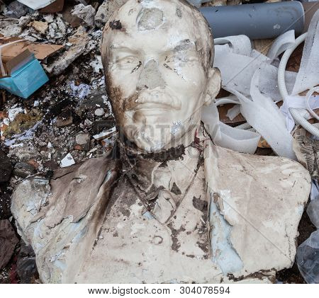Decommunization In Ukraine. Damaged Bust Of Lenin In The Garbage Dump. Close-up.