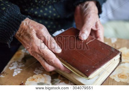 Old Woman Hands Holding The Prayer Book. Close-up.