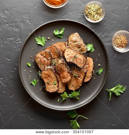 Grilled Beef Liver On Plate Over Black Stone Background. Cooked Liver(offal) From Beef Meat. Top Vie