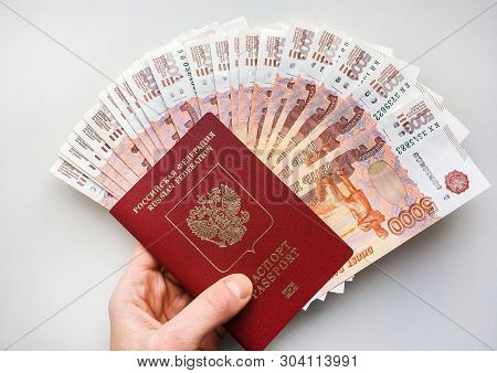 Russian Money And Passport On A Gray Background, Close-up, Passport And Money Fan In Hand