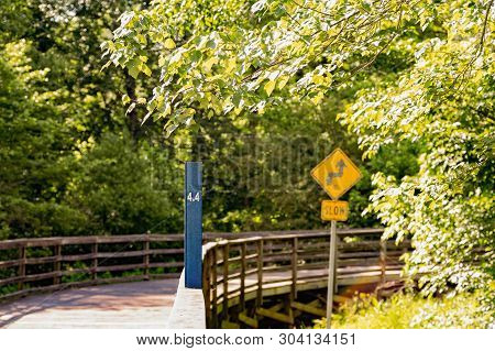 Milage Sign And Curve Warning On A Walking, Running, Biking And Fistness Trail Through Woodlands And