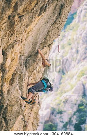 Rock Climbing And Mountaineering In The Paklenica National Park. A Woman Overcomes A Challenging Cli