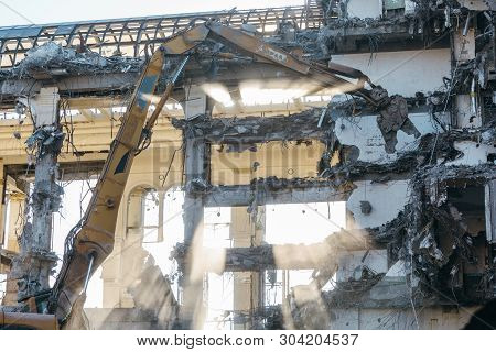 Excavator With Long Mechanical Arm At Height Breaks Off Pieces Of The House. Cleaning Area For A New
