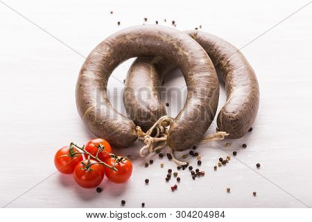 Food, Cuisine And Horsemeat Concept - Close Up Of Meat Sausage With Tomatoes And Pepper On Kraft Pap