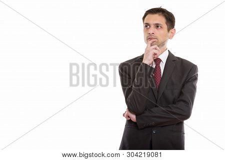 Studio Shot Of Young Businessman Thinking While Looking At Dista