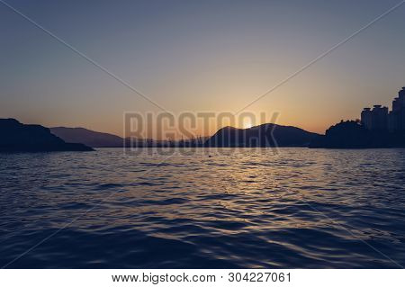 View From The Sea On Sunset Over Busan Landscape With Hills And Buildings