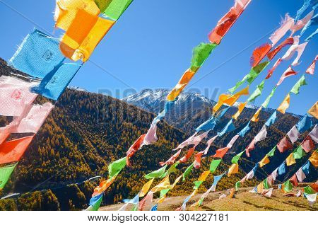 Colorful Tibetan Flags And Snow Mountain At Siguniang Scenic Area In Autumn Season,chengdu, China.