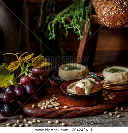 Soft Spreadable French Stinky Cheese On A Slice Of Bread With Fruit And Pine Nuts, Square