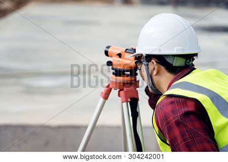 Surveyor Engineer With Theodolite At Construction Site During Surveying Work.engineer And Architect 