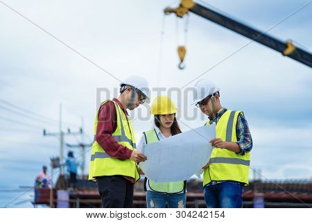 Foreman 3 People Are  See A Blueprint About The Factory Building Structure On The Job Site.foreman, 