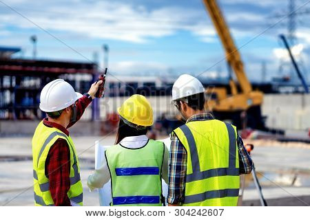 Foreman 3 People Are Held A Blueprint To Discuss The Construction Structure.woman Engineers Wear Saf