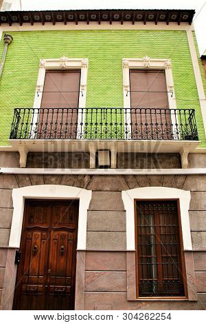 Old Colorful And Majestic Tiled Facades With Vintage Streetlight In Elche, Alicante, Spain. El Raval