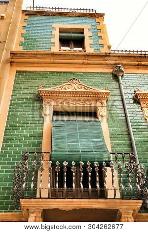 Old Colorful And Majestic Tiled Facades With Vintage Streetlight In Elche, Alicante, Spain. El Raval