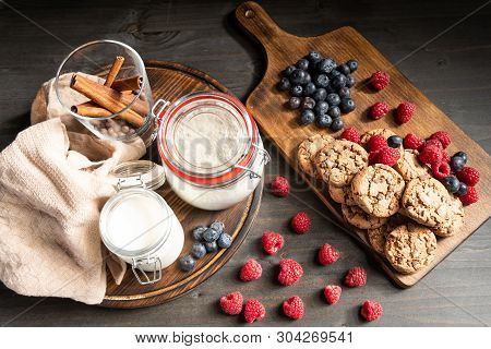 Raspberries, Homemade Cookies And Milk On Wooden Support, Top View