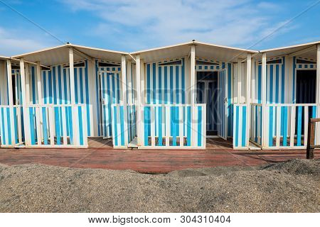 Striped White And Blue Striped Beach Houses And Black Sandy Beach, Tyrrhenian Sea Near Roma, Italy
