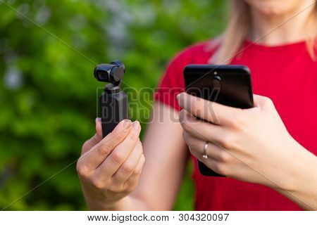 Close Up Picture Of Osmo Camera And Smart Phone In Female Hands